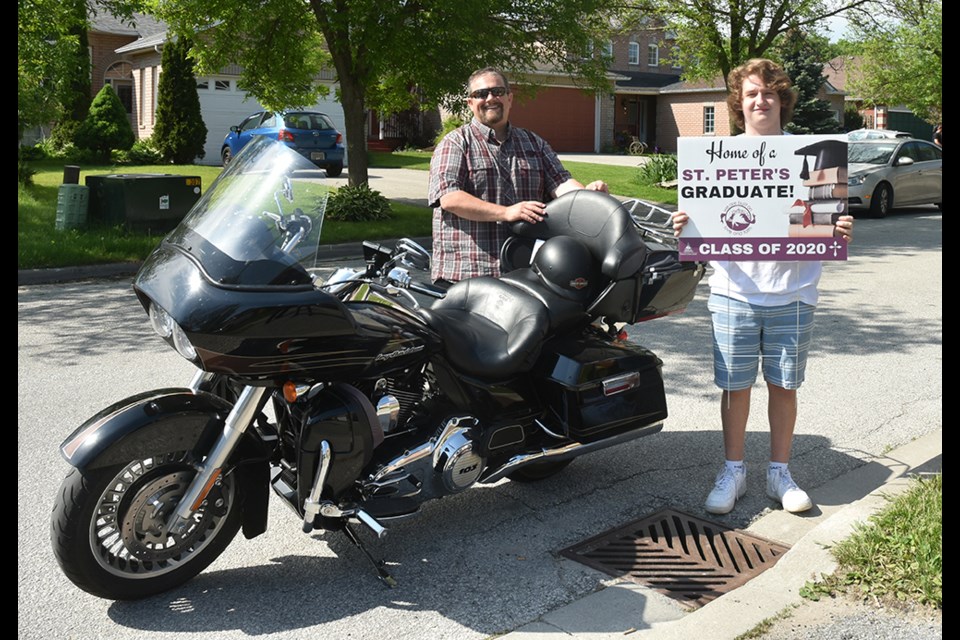 St. Peter's Catholic Secondary School Principal Brad Shoreman presents a lawn sign to graduating student Anthony Ventimiglia. Miriam King/Innisfil Today