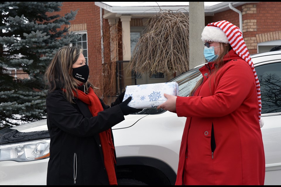 Innisfil Mayor Lynn Dollin, left, presents a gift to Jennifer Richardson, organizer of the Light It Up Innisfil contest - from InnPower.