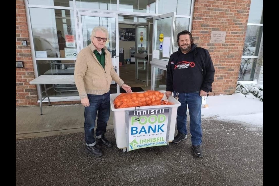 Pastor Howard Courtney (left) from the Innisfil Community Church receiving 140lbs of carrots and onions for the Innisfil Food Bank from Nubridge Auto Centre owner Alex Sallal (right).   /PhotoSubmitted