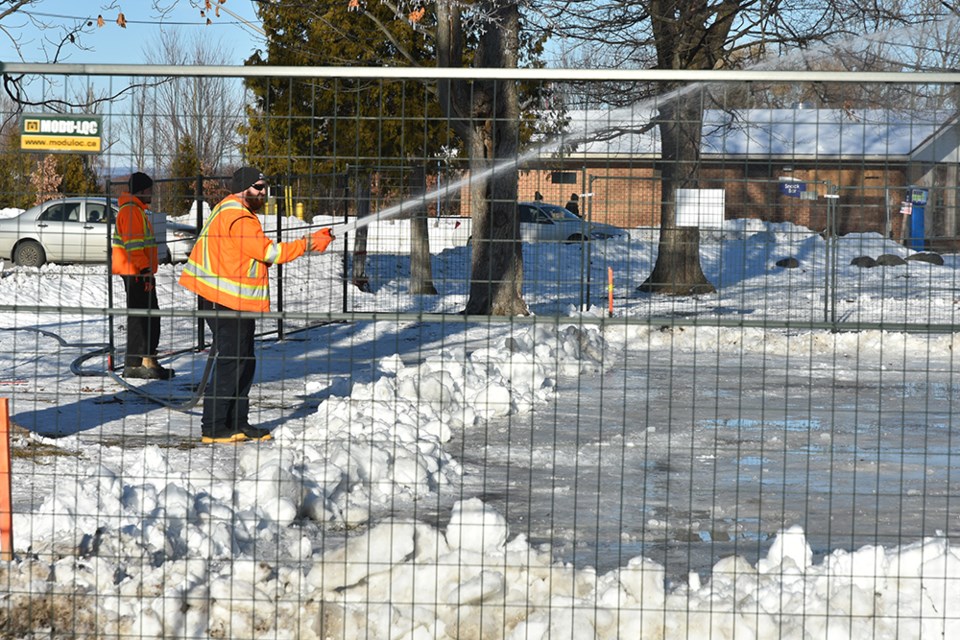 Town staff build up a layer of ice at an outdoor rink in Innisfil Beach Park.