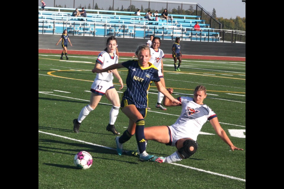 Portage midfielders Ashley Tether (right) tries for a slide-tackle on Ooks midfielder Ally Martineau as Voyageur teammate Brooklyn Haub approaches during the 2023 home opener for the women's and men's soccer squads on Sept. 15 in which the Voyageur women lost 4-0 and the men 7-0.
