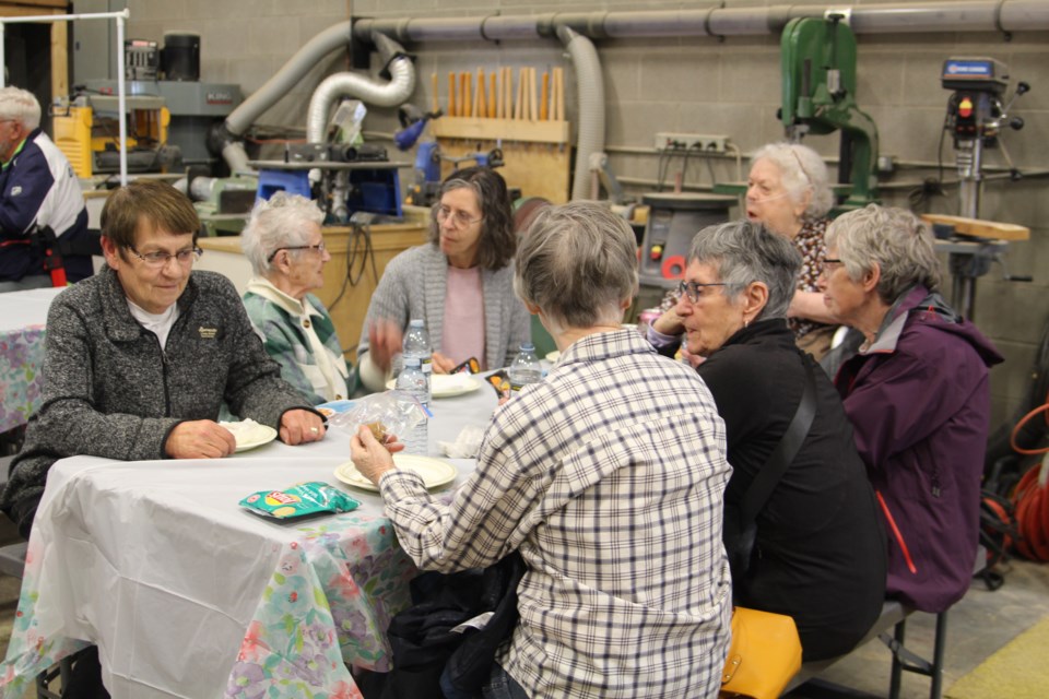 Seniors at the barbeque enjoying each other's company at the Age Friendly men shed.