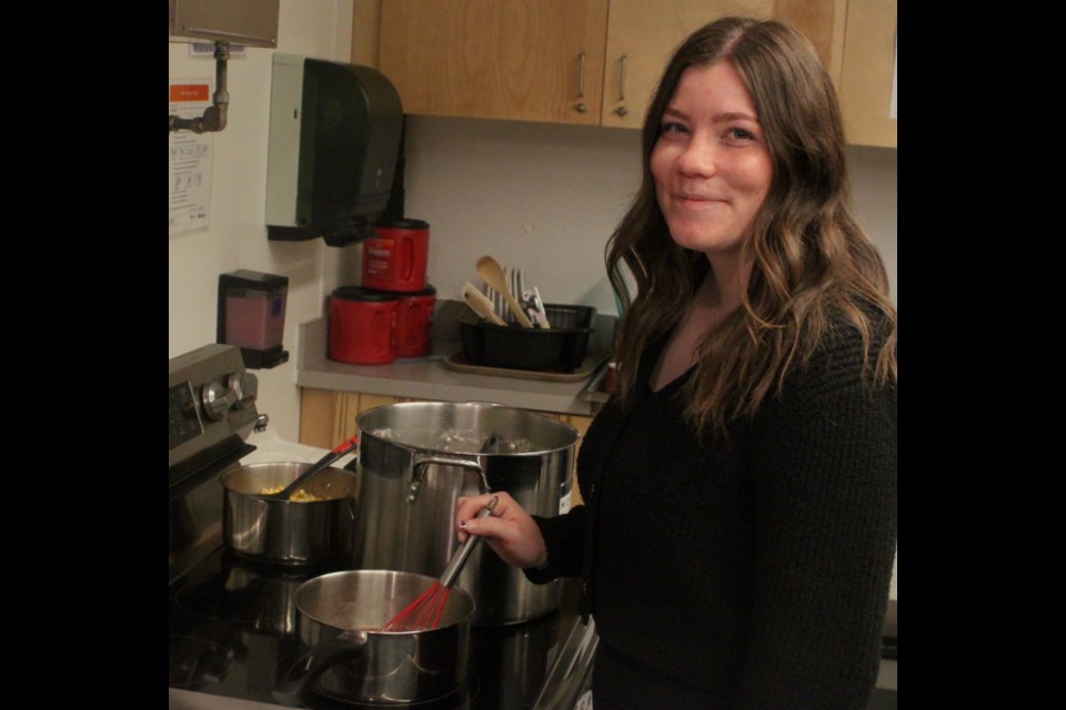 Alana Reid stirs a pot of gravy that was served as part of the meal. Chris McGarry photo. 