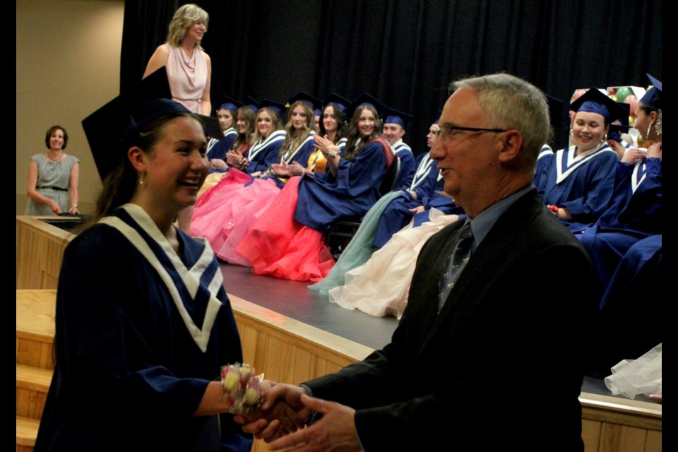 Anastacia Ambanoudis shakes hands with Blair Norton, a member of the Northern Lights Public Schools (NLPS) board of trustees after receiving her diploma. Chris McGarry photo. 