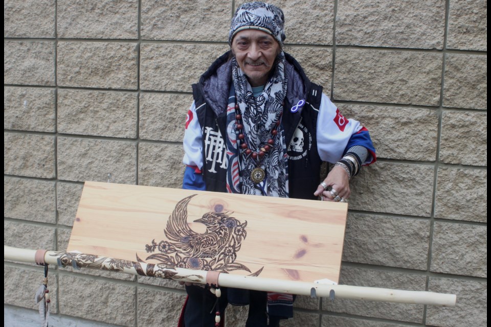 Lac La Biche area artist Andrew Boostrum stands with some of his artwork, which includes carved walking sticks as well as a stick holder engraved with traditional Indigenous images. Chris McGarry photo. 