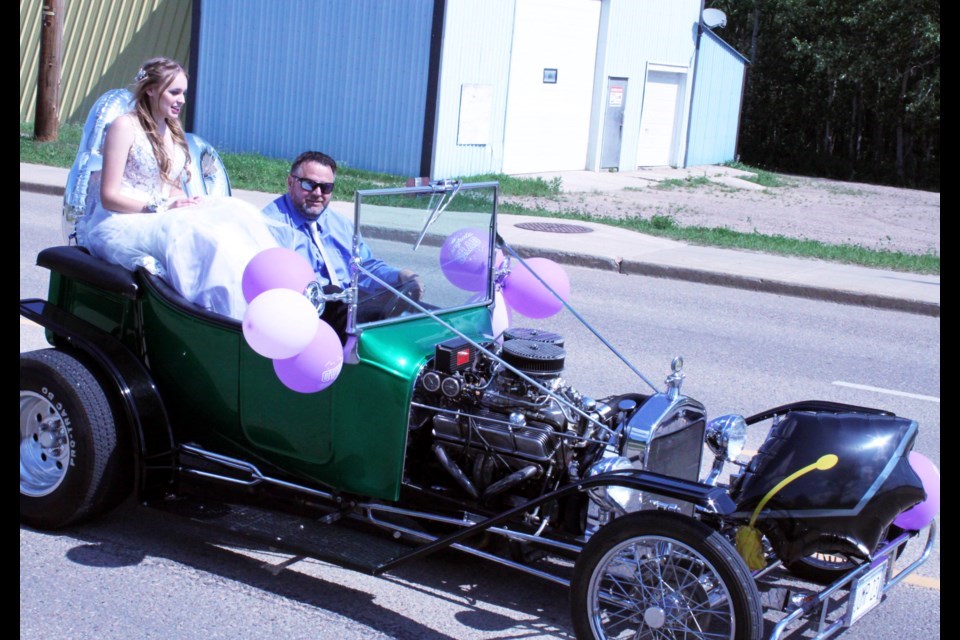 With her dad Kevin at the wheel of a family hot-rod, JAWS grad Avery Kuraitis rides in style for the 2023 parade. Chris McGarry photo. 