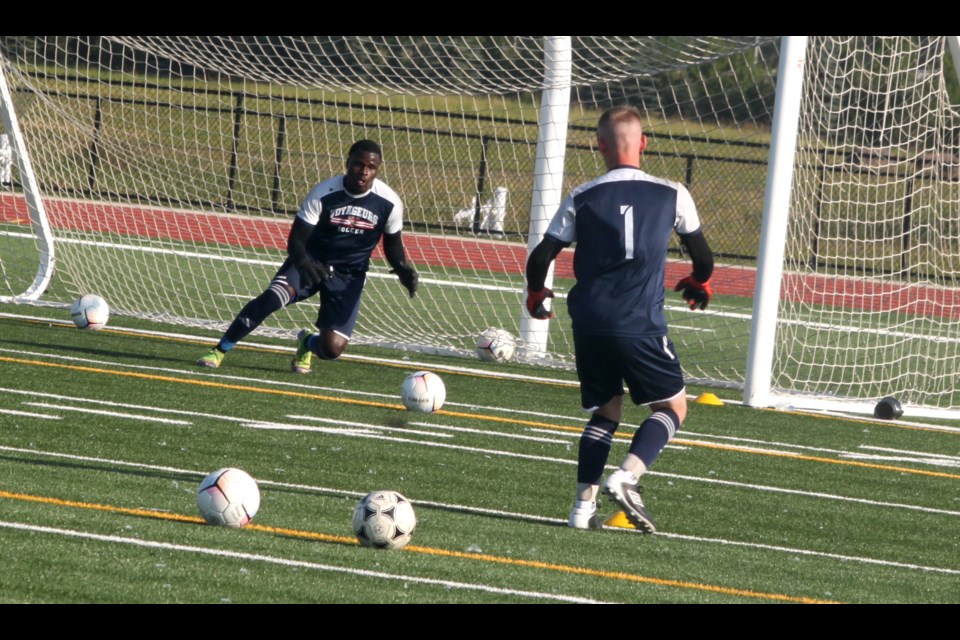 Fiston Kiese gets ready to stop an attack from Ben Kenny, a native of Belfast, Northern Ireland, who is a goalkeeper for the Portage College Voyageur’s men’s squad for the 2024-2025 season. The men’s and women’s squads participated in a training session Monday at the Bold Centre turf. Chris McGarry photo. 