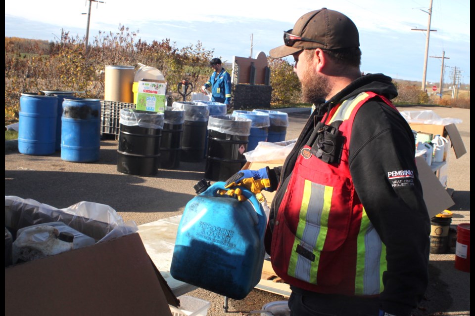 Brennan Scott, the Ag Fieldman for Lac La Biche County handles a container of old gas and diesel mix during the household hazardous waste and roundup and shredding event, which was held at the County Center on Saturday, Oct. 19 as part of Waste Reduction Week activities in the region. Chris McGarry photo. 