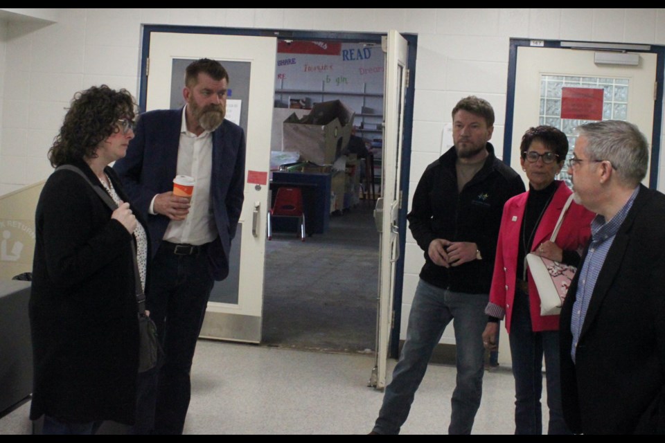 Brian Jean, MLA for Fort McMurray-Lac La Biche, chats with Karen Packard, chair of the Northern Lights Public Schools (NLPS) board of trustees, Lac La Biche Mayor Paul Reutov, NLPS Superintendent Rick Cusson, and Colette Borgin, Ward 3 councillor for Lac La Biche County during the tour of Ecole Plamondon on Friday, May 3. In the background is the Plamondon Library, which is housed in the same building and also sustained damage during the flood that swept through the school on the afternoon of Thursday, May 18. Chris McGarry photo. 