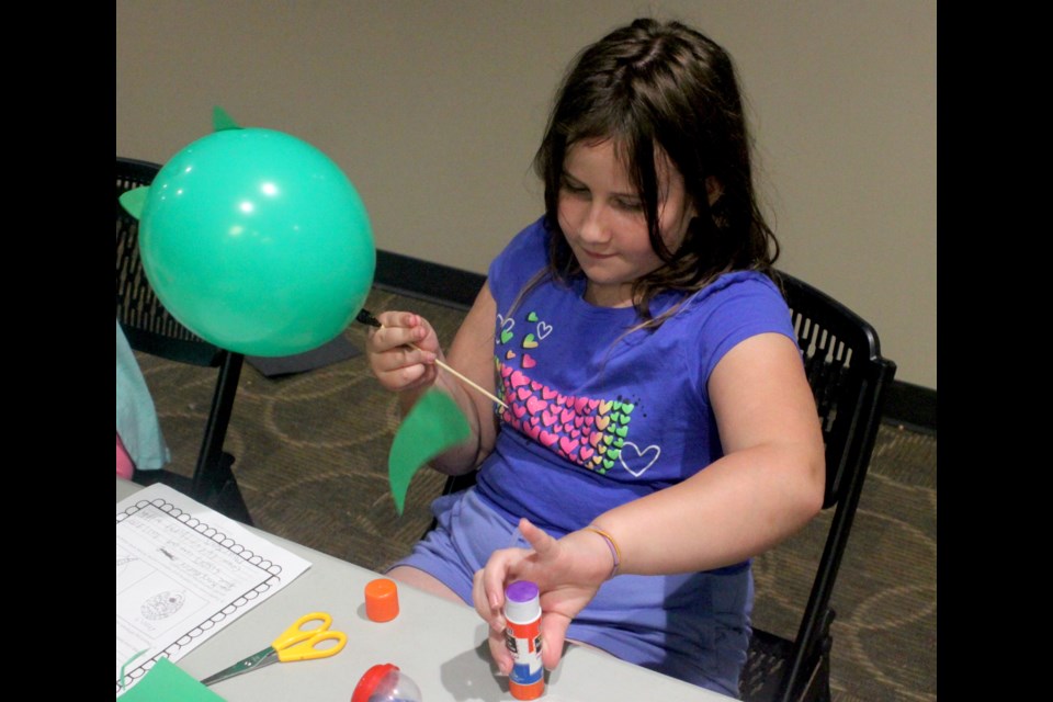 Brook Bobocel was one of around a dozen kids who participated in the S.T.E.A.M (Science, Technology, Engineering, Arts and Mathematics) camp that took place at the Bold Center from Aug. 19-23. Here, Brook works on a project which involved participants making designs out of construction paper and other materials to dress up balloons. Chris McGarry photo. 