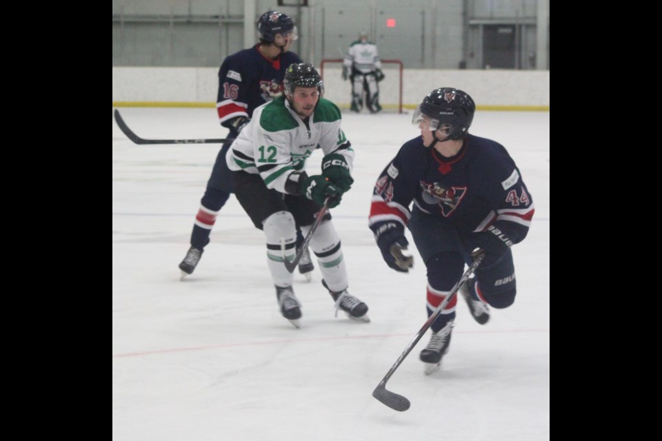 Brydon Bell of the Portage College Voyageurs looks over his shoulder as he’s pursued by Red Deer Polytechnic’s Nolan Doell. Chris McGarry photo. 