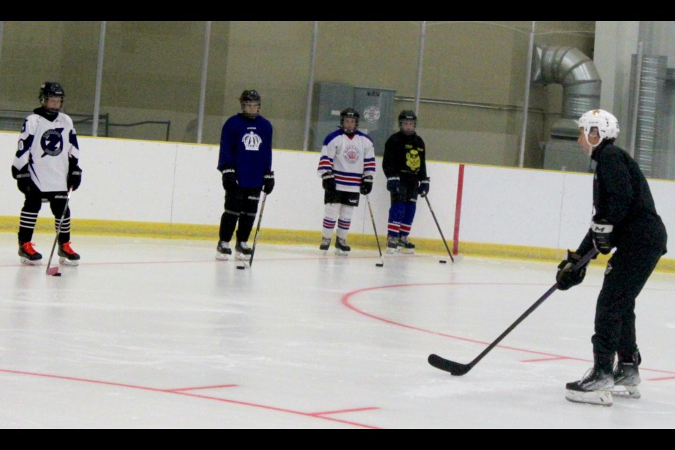 The young hockey players who attended Ski’s Skills Hockey camp at the Bold Center on Monday, Aug. 28 listen as Carter Wolski gives instructs on how to skate quickly while handling the puck. Chris McGarry photo.