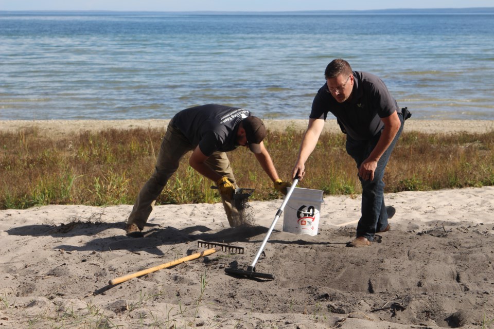 Chris Vandenborn (right) manager of Achieving Eden the Landscape Company, and a company worker cleaning up the more hazardous materials.