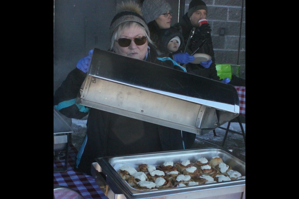  Colleen Gill takes the cover off a warming tray, where cinnamon buns were kept until being served during the 2024 Family Day. Chris McGarry photo.