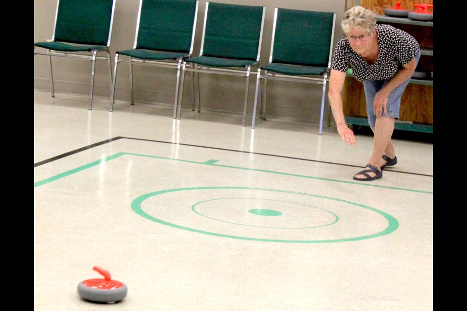 Davina Vetzal participates in a floor curling game at the Lac La Biche Heritage Society. Chris McGarry photo.