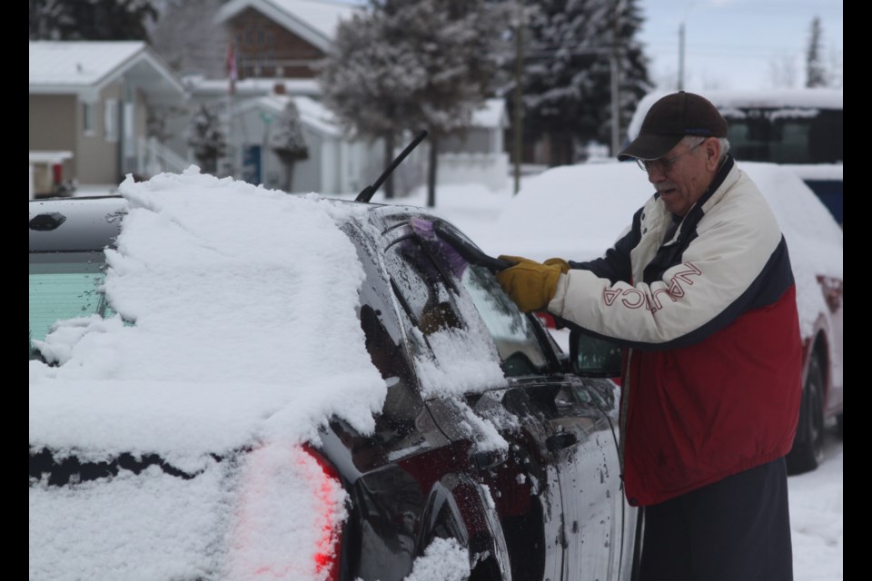 George Demerais had his work cut out for him cleaning off his car following heavy snowfall in the Lac La Biche area on Thursday, Jan. 16. Chris McGarry photo. 