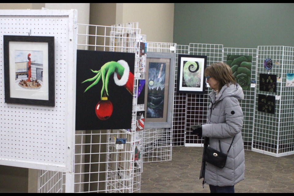 Donna Steele looks over some of the exhibits that were on display inside the Bold Center during the 2024 Fabulous North Art Exhibition and sale, which took place alongside the Festival of Trees and the Christmas Shopping Extravaganza from Nov. 22-24. Chris McGarry photo. 