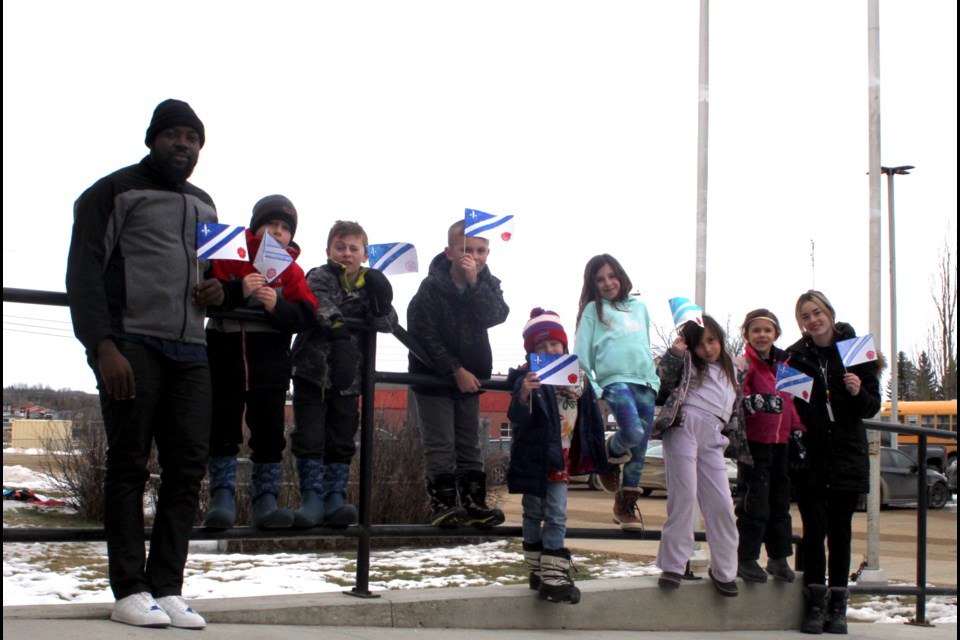 Students and staff from Ecole Beausejour School in Plamondon waving the Franco-Alberta flag at the flag raising event on March 3. Chris McGarry photo. 