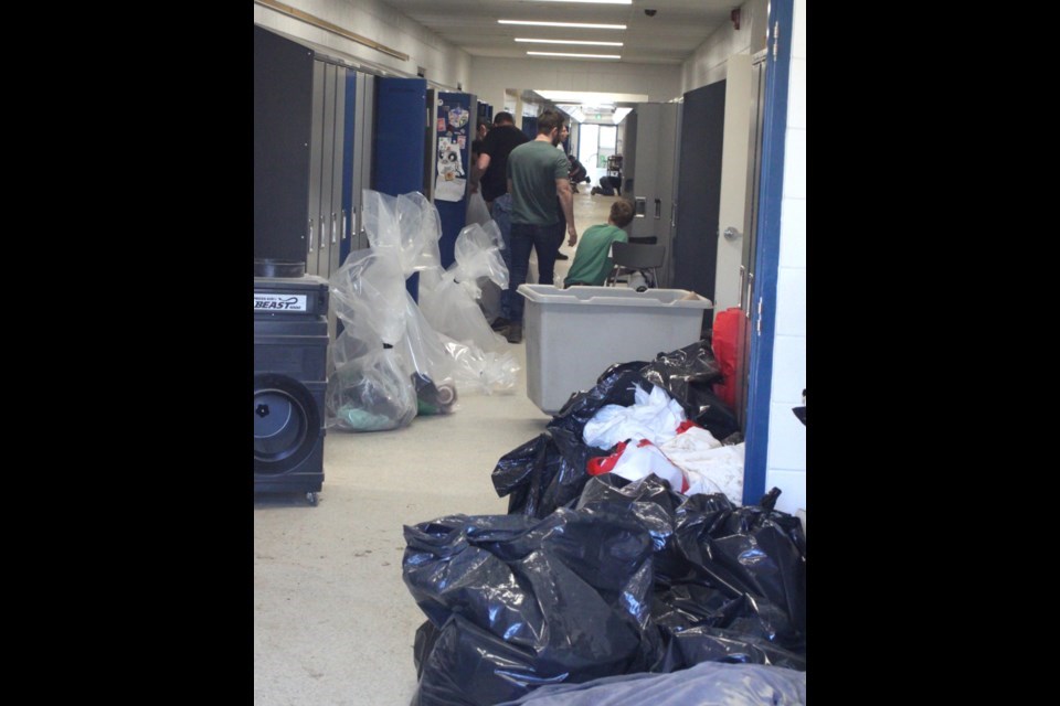 Crews working through the damage caused by a massive flood to Ecole Plamondon School on April 18. The building is set to be reopened for the start of the 2024-2024 school year. Chris McGarry photo. 