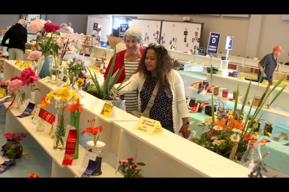 Ethel Grier and Mae Gargar peruse the variety of flowers, vegetables and other items on display at the horticultural bench show, which took place Friday from 2-6 p.m. Chris McGarry photo.