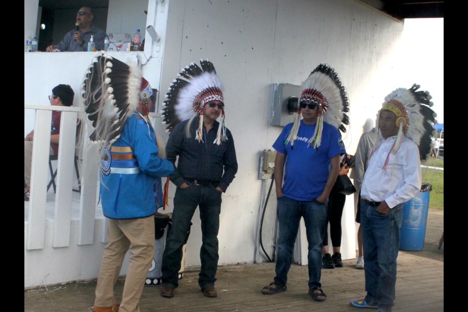 A meeting of the chiefs. Gary Lameman, chief of Beaver Lake Cree Nation, chats with visiting chiefs Herb Jackson (Whitefish Lake First Nation), Kelsey Jacko (Cold Lake First Nation), and Henry Lewis (Onion Lake First Nation) prior to the start of the Grand Entry on Friday evening. Chris McGarry photo. 