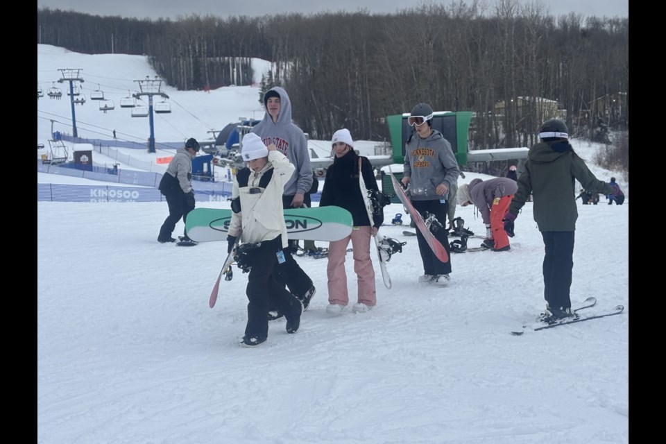 Snowboarders at Kinosoo Ridge roam the hill, ready to hit the slopes.