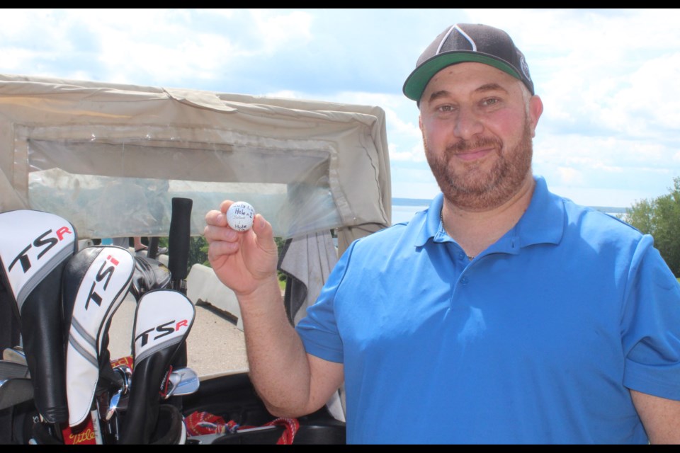 Ali Abougouche at the Lac La Bcihe Golf Club with the ball that he says will never be hit again. He made the 154 yard shot with a seven-iron.