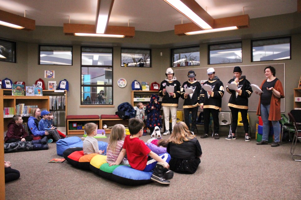 Members of the Bonnyville Pontiacs hockey team volunteered for a readers theatre performance of Robert Munsch's 'Pigs.' From left are: Pontiac players Maxim Shushkov, Brayden Gourley, Rockston Ror-Chow, and Nate Crashley with Library Programmer Kat Eliason.