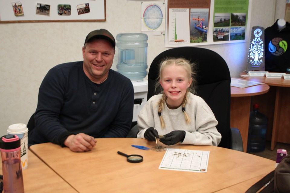 Robert Livingston and his daughter Ellen Livingston as she dissects a rodent skull from her owl pellet.