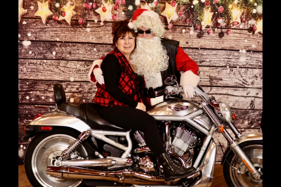 Organizer for the Biker Santa event Myrtle Beaulieu at the Legion poses on a Harley V-Rod with the big man himself 