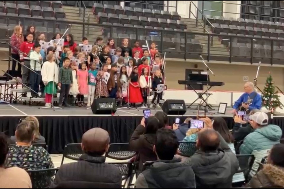 Brian Deheer strums along with the kids to "I want a hippopotamus for Christmas" during Friday's Lac La Biche Choir presentations at the Bold Center