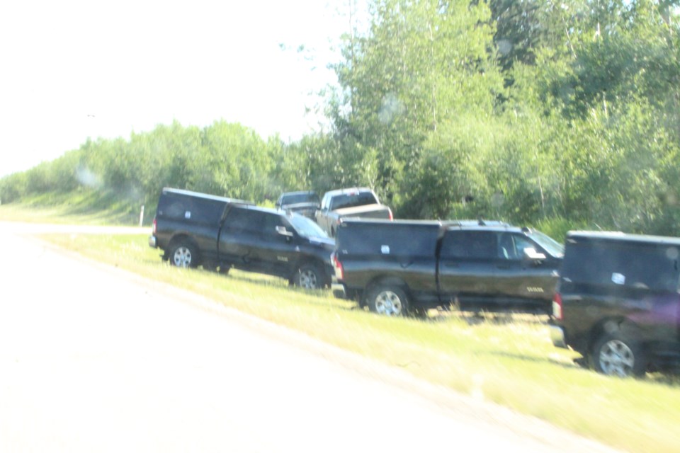 Matching dark coloured pickup trucks lined a ditch near a residential property just south of Lac La Biche on Tuesday afternoon.