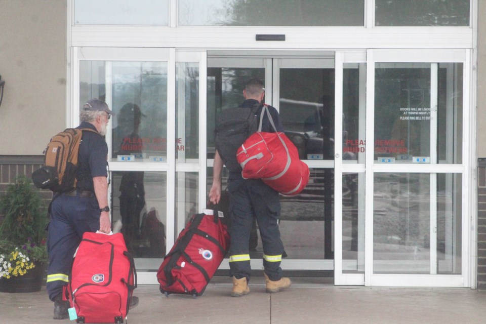 FIrefighters from Australia make their way into a Lac La Biche hotel, part of a group of several dozen international firefighters arriving to assist with northern Alberta wildfires.