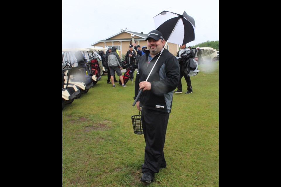 Lac La Biche Golf Club pro Lance Palamaruk poses for the camera with a rain parasol before a recent tournament at the course. Weather has been in "extremes" from rain to heat over the last few weeks. 