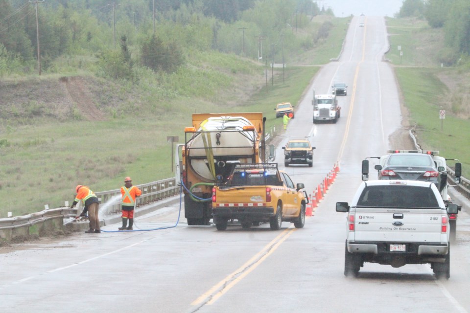 High pressure hoses helped to reach the places the rain couldn't during a scheduled bridge cleaning by Emcon highway maintenance crews near Bonnyville on Thursday afternoon.