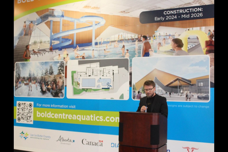 Lac La Biche County Mayor Paul Reutov stands in front of the most recent design plan of the $46 million pool project that is slated to be open in late 2026