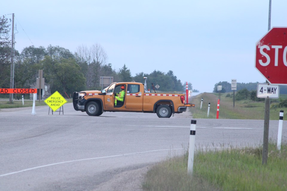 A highway maintenance crew from Emcon Services monitors barricades blocking through-access to Highway 831 north of Highway 45 on Sunday night. RCMP have yet to provide details on what is believed to have been a crash on the Waskatenau Bridge 25 kilometres north of the roadblock.   Image Rob McKinley