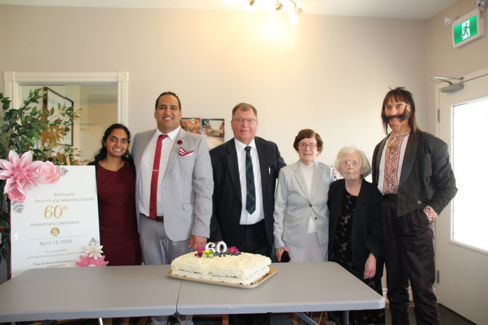 Pastor Grant and Sahana Lottering, Pastor Robert and Gabriele Pohle, Mary Synowec and Dale Synowec stand near a celebration cake.