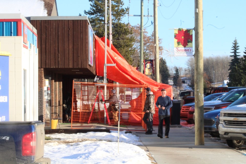 Pedestrians move around the orange tarped area of new business construction taking place in Plamondon.    Image Rob McKinley