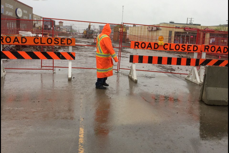 A construction worker takes a wet walk around the downtown project on a wet Wednesday afternoon. 