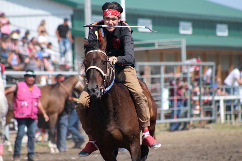 Whitestone Relay Team warrior, Johnny Whitstone, urges his horse on during the Xtreme Indian Relay Race.