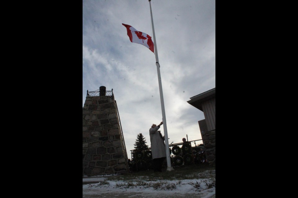 Legion executive member Pete Shamchuk lowers the Canadian flag to half mast during the Lac La Biche Remembrance Day ceremony.