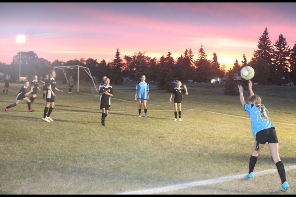 A Vegreville Thunder U13 player throws-in to her teammate as the Bonnyville Black Widows cover the area in a Saturday night sunset game at the Camrose Night Classic. Vegreville went on to win the game 2-1.