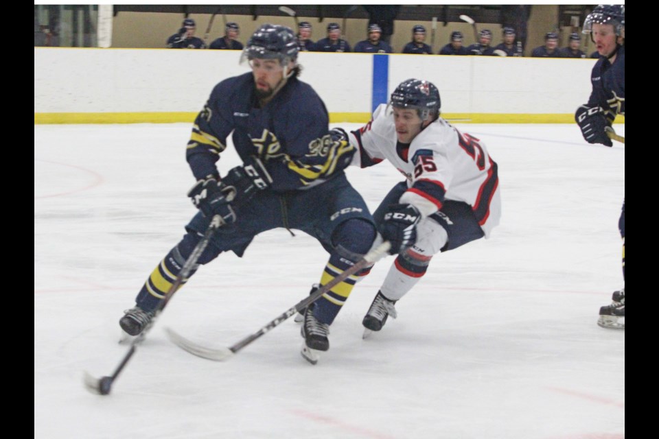 Clippers Landon Russell gets some attention from the Voyageurs' Logan Spence during Saturday's game. Portage dropped the game 3-0 to the Briercrest College team.