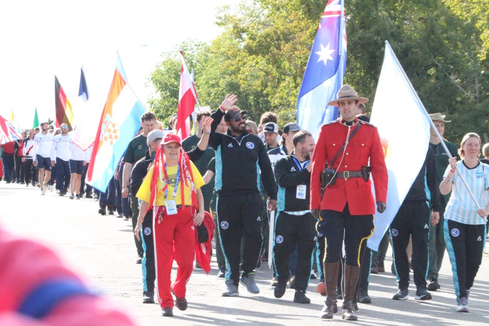 All smiles for the opening ceremonies parade as athletes and volunteers ... and a Mountie ... filled Churchill Drive in Lac La Biche on their way to the opening ceremonies in McArthur Park