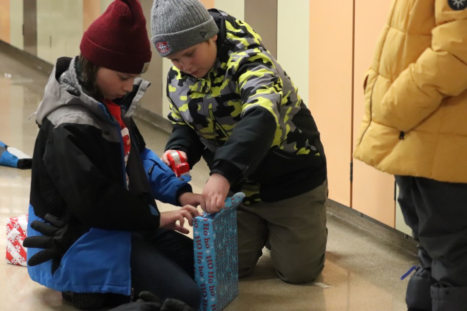 St. Paul Elementary students wrap gifts for Santa's Elves.