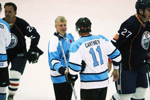 Laurie Hawn shakes hands with NHL Hall of Famer Mike Gartner after his team of MPs lost to Team Wheeler at the Afterburner Cup at 4 Wing on Nov. 6. At photo left is Oilers