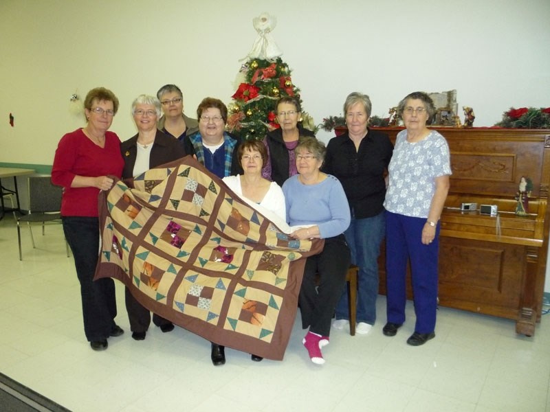 The Mallaig Flying Needles quilting club dedicated and gave a quilt in the memory of Cecile Brochu to Brochu&#8217;s daughter, Anne-Marie Amyotte (second from left). Standing 