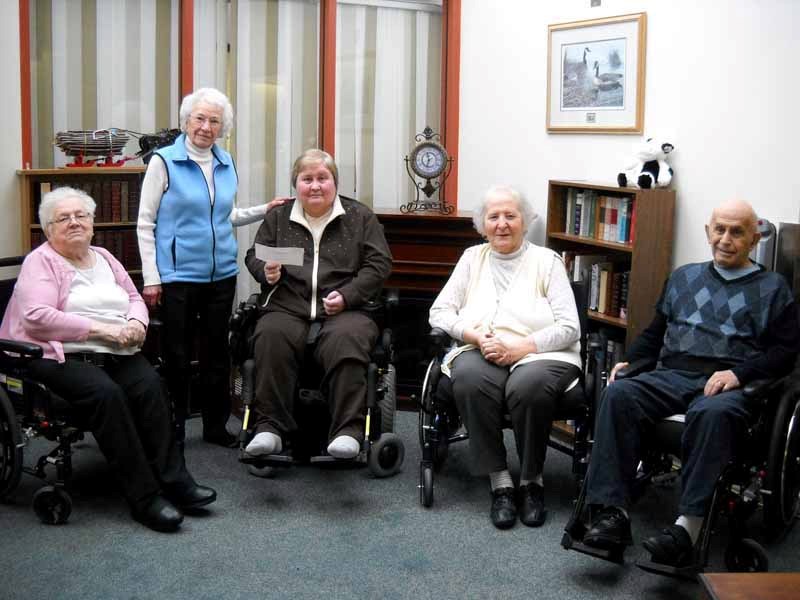 Yvonne Joly (second from left) presents a cheque for $23,547 to the J.P. Decosse Auxiliary Hospital residents on behalf of the late Albertine Socquet. Socquet was a resident