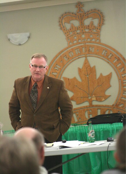 Joe Anglin holds up a needs assessment for a transmission proposal at a public meeting on Wednesday at the St. Paul Legion.